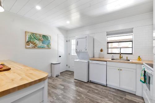 una cocina con armarios blancos y fregadero en Paradise Palms- Tropic Suite- Pool - Steps to Ocean - 10 min to Downtown en St. Augustine