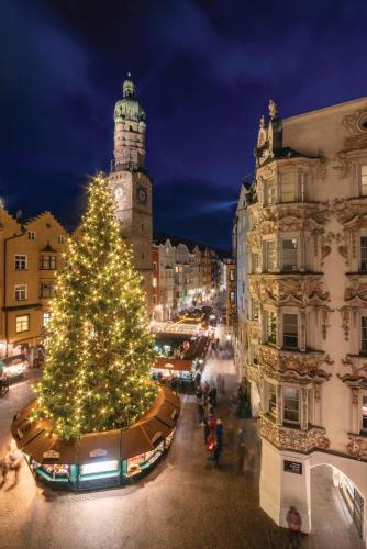a christmas tree on a city street with a clock tower at Big place in city center with parking in Innsbruck