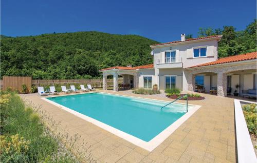 a swimming pool in front of a house at Amazing Home In Veprinac With 5 Bedrooms, Sauna And Wifi in Veprinac