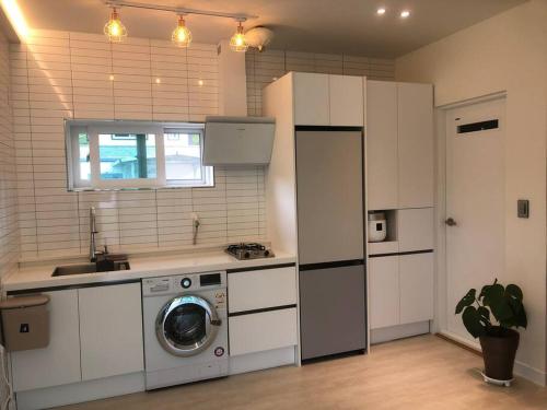 a kitchen with a washing machine and a sink at Yangyang, Stay There in Yangyang