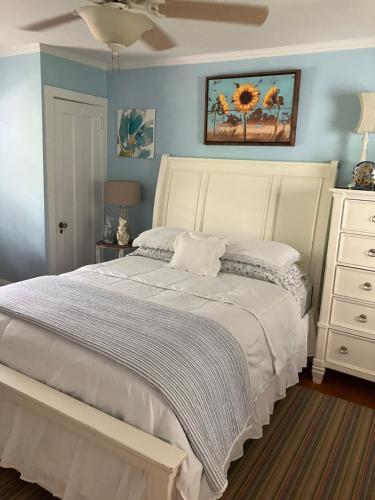 1 dormitorio con cama blanca y pared azul en 9 Booth Lane, en Haverford