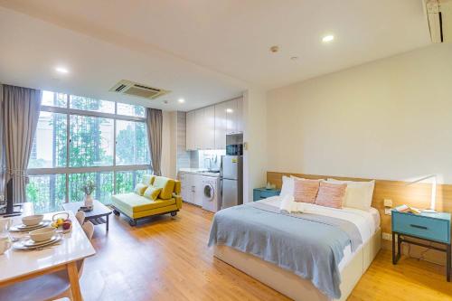 a bedroom with a large bed and a kitchen at Thanksgiving Serviced Residence in Singapore