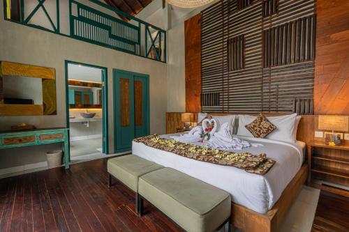 1 dormitorio con 1 cama grande y baño en The Reward Villas Kerobokan en Seminyak