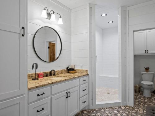 a bathroom with a sink and a mirror and a toilet at Stunning Luxury Cabin w Hot Tub and Fire Pit Holy Shiplap is Perfect Romantic Couples Getaway in Broken Bow