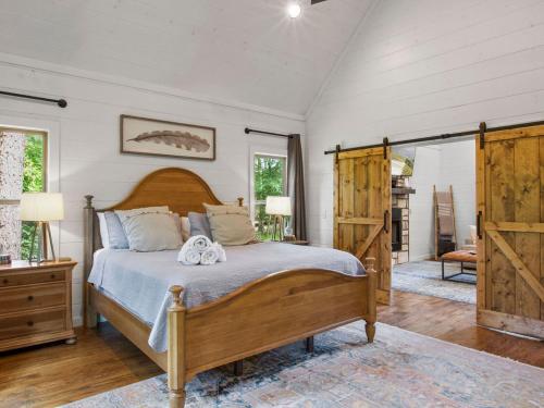 a bedroom with a bed with a wooden head board at Stunning Luxury Cabin w Hot Tub and Fire Pit Holy Shiplap is Perfect Romantic Couples Getaway in Broken Bow