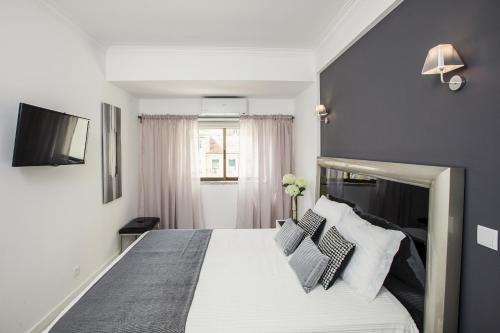 - une chambre avec un grand lit aux murs bleus dans l'établissement D_Loft River, à Lisbonne