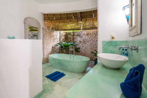 a bathroom with a tub and a sink at Villa Nirvana Biru Bingin Beach in Uluwatu