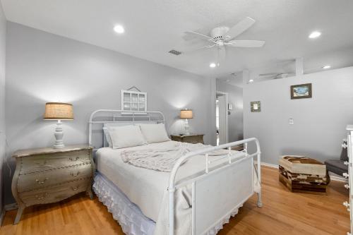 a bedroom with a white bed and a ceiling fan at Fountain of Youth House - Scenic Downtown Retreat in St. Augustine