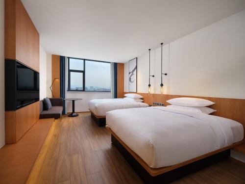 ein Hotelzimmer mit 2 Betten und einem TV in der Unterkunft Fairfield by Marriott Yuyao in Yuyao