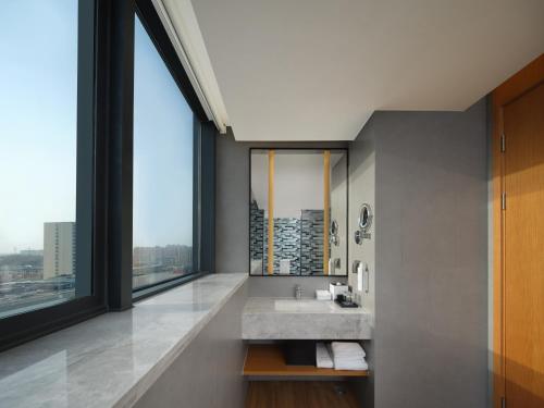 ein Badezimmer mit einem Waschbecken und einem großen Fenster in der Unterkunft Fairfield by Marriott Yuyao in Yuyao
