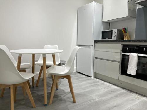 une cuisine avec une table et des chaises dans l'établissement Watford City Centre Retreat - Spacious Modern Self-Contained Apartment - Sleeps 4, à Watford