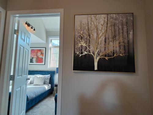 a bedroom with a picture of a tree on the wall at The Lambeth by Samsara Resort Private Entry Panorama Top View 2BR and 2BTH in Canmore