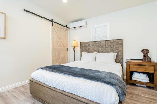 a bedroom with a large bed and a wooden table at Newly Remodeled 2B1B House on Historic Route 66 in Glendora