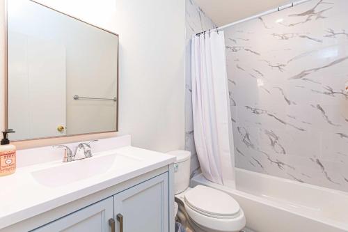 a white bathroom with a sink and a toilet at Newly Remodeled 2B1B House on Historic Route 66 in Glendora