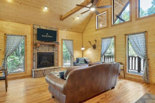 a living room with a couch and a fireplace at Gorgeous Idyllic Cabin w Hot Tub and Fire Pit Quittin Time is Secluded Romantic Oasis w Luxury Bathroom Double Shower and Bathtub Foosball Table in Broken Bow