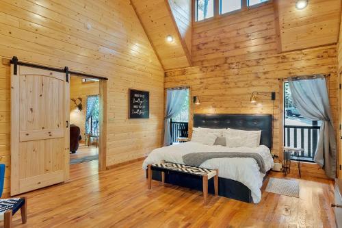 a bedroom with a bed in a wooden cabin at Gorgeous Idyllic Cabin w Hot Tub and Fire Pit Quittin Time is Secluded Romantic Oasis w Luxury Bathroom Double Shower and Bathtub Foosball Table in Broken Bow
