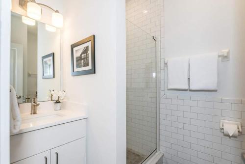 a white bathroom with a sink and a shower at The Studio at Old Mission Walking Distance to Downtown and Onsite Parking in Saint Augustine