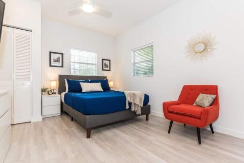 1 dormitorio con 1 cama y 1 silla roja en The Studio at Old Mission Walking Distance to Downtown and Onsite Parking en Saint Augustine