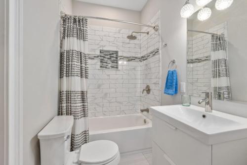 baño blanco con lavabo, bañera y aseo en Oneida Charmed - Historic Cottage w Modern Flair, en St. Augustine
