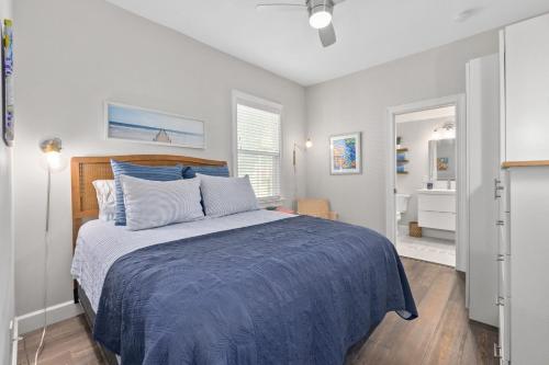 a bedroom with a bed with a blue comforter at Oneida Charmed - Historic Cottage w Modern Flair in Saint Augustine