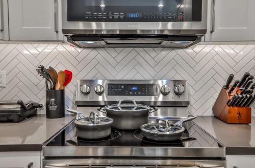 a kitchen with two pots on a stove at The Parq by Samsara Resort Top View Downtown 4BR & 3BTH in Canmore