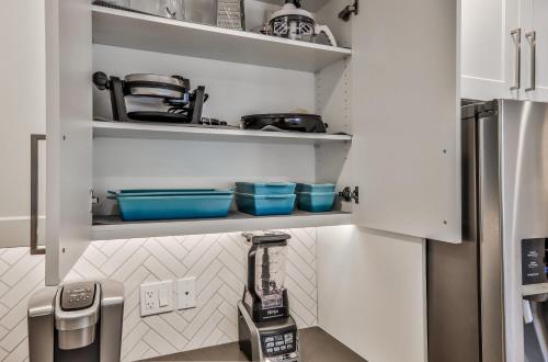 a kitchen with white cabinets and a refrigerator at The Parq by Samsara Resort Top View Downtown 4BR & 3BTH in Canmore