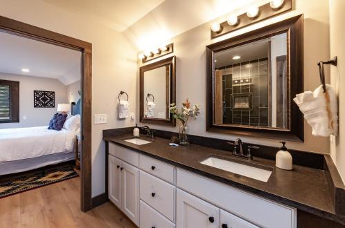 a bathroom with a double sink and a bed at Bowling Waterfront Luxury MtnViews Pool Sleeps12 in Sevierville