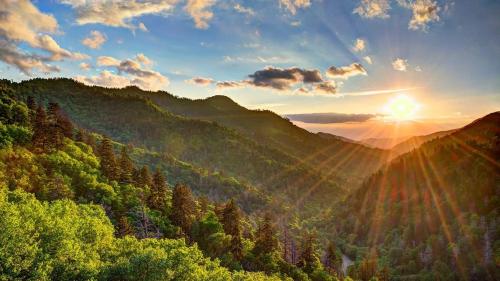 a view of a mountain valley with the sun setting at Bowling Waterfront Luxury MtnViews Pool Sleeps12 in Sevierville
