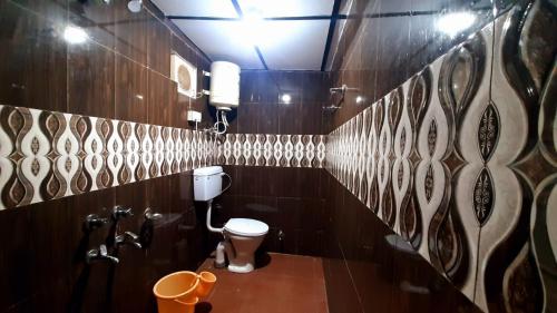 baño con aseo y paredes de madera en Thrillomania Mcleodganj en Dharamshala