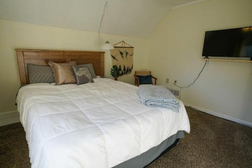a bedroom with a white bed and a flat screen tv at 2 Bedroom Apartment near NDSU and Downtown Fargo in Fargo