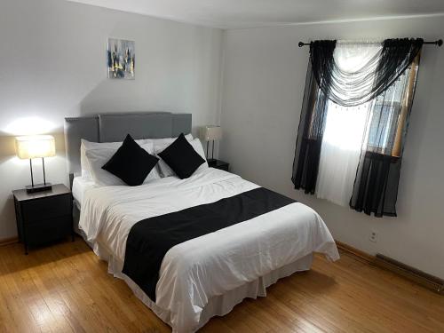 a bedroom with a large bed with black and white sheets at Elite Casa Collection -free coffee, parking, and Wi-Fi in Milwaukee