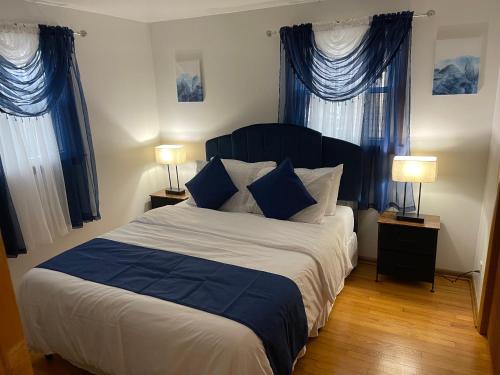 a bedroom with a large bed with blue curtains at Elite Casa Collection -free wine, coffee, Wi-Fi, parking in Milwaukee