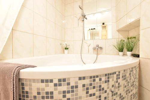 y baño con bañera y paredes de azulejos. en Riesiges zentrales Apartment mit Parkplatz, en Innsbruck
