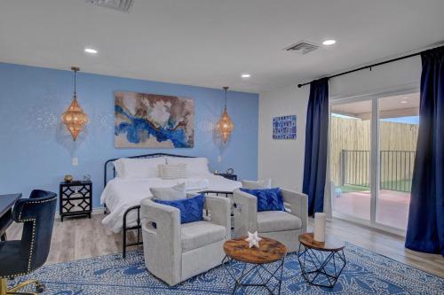 Schlafzimmer mit einem Bett mit blauen Wänden und Stühlen in der Unterkunft Buddha Mansion Luxury Resort - 8BR Modern, HotTub, Huge pool, Sauna, BBQ grill, Game Room in Las Vegas