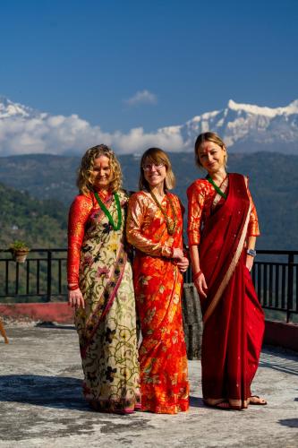 three women standing on top of a mountain at Barang Village Community Homestay in Pokhara