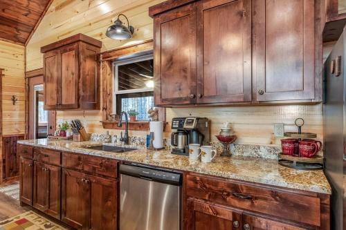 a kitchen with wooden cabinets and a stainless steel appliance at Large Luxury 2BR Cabin w Hot Tub Double Trouble was designed for fun comfort and memories minutes from buzzling Hochatown and beautiful Beaver Bend State Park in Broken Bow