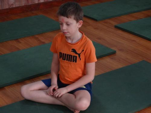 a young boy sitting on a yoga mat at Village Homestay with Culture and Nature in Pokhara