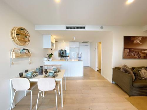 a living room and kitchen with a table and chairs at Elegant and Cozy Top Floor 1BD Apartment at South Bank in Brisbane