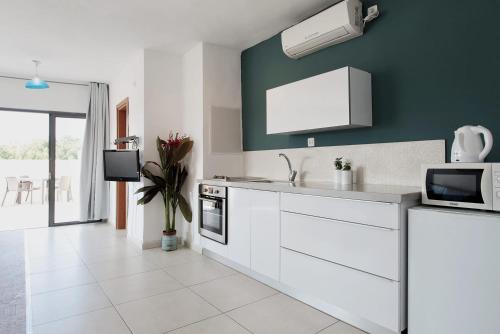 a kitchen with white appliances and a green wall at Beautiful Studio in Flea Market By Holiday Rentals in Tel Aviv