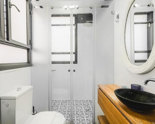 een badkamer met een zwarte wastafel en een spiegel bij Amazing 2BR in Gideon by Holiday-rentals in Tel Aviv