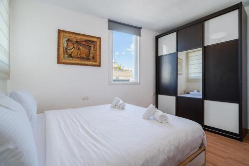 a white bedroom with a white bed and a window at 2BR - 2 12 Hei be-Iyar St Tel aviv in Tel Aviv