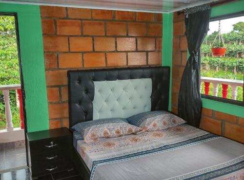 a bed in a room with a brick wall at Finca Villa Hermosa in Alcalá