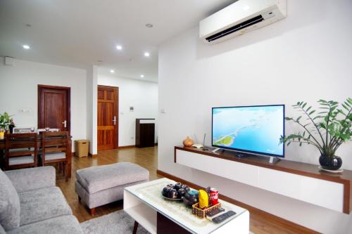 a living room with a flat screen tv on a wall at QMP Friendly House PKB in Hanoi