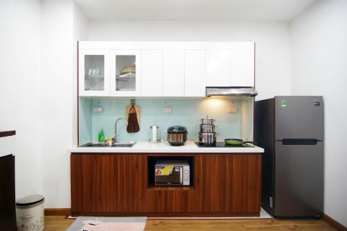 a kitchen with a sink and a refrigerator at QMP Friendly House PKB in Hanoi