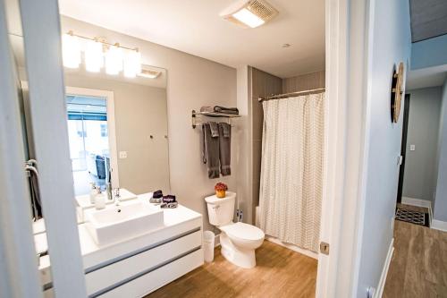 ein Badezimmer mit einem weißen Waschbecken und einem WC in der Unterkunft Modern 2 BR with Balcony in GR Entertainment District in Grand Rapids