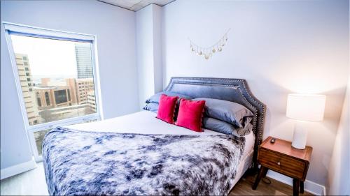 a bedroom with a bed with pink pillows and a window at Modern 2 BR with Balcony in GR Entertainment District in Grand Rapids