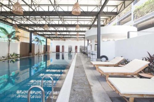 una piscina con tumbonas y una piscina en Urban Village Night Stay, en Phnom Penh