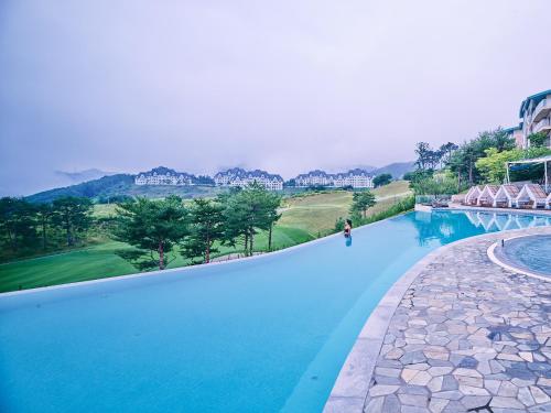 a swimming pool with blue water in a resort at Sono Felice Village Vivaldi Park in Hongcheon