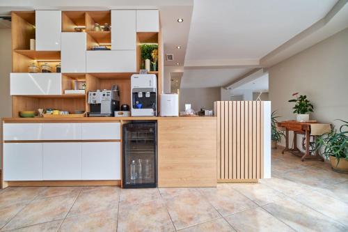 a kitchen with white cabinets and a coffee machine at Hotel Amfora in St. St. Constantine and Helena