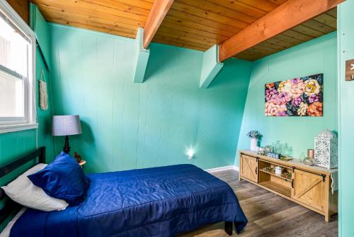 a bedroom with green walls and a blue bed at Private Lake&Beach Cabin, Golf, Fire Pit, & WiFi! in Terra Alta